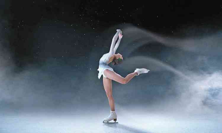 Bailarina patina no gelo, de perfil, com os braos levantados
