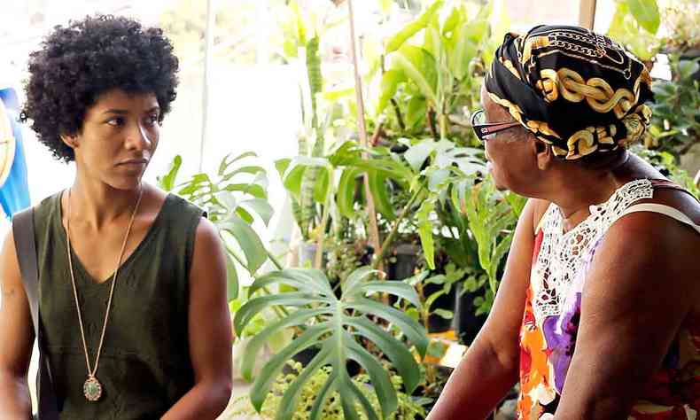 Jovem mulher conversa com senhora de turbante, ambas negras, no filme ''Matriarcas da Serra'', sobre a histria do Aglomerado da Serra, em BH 