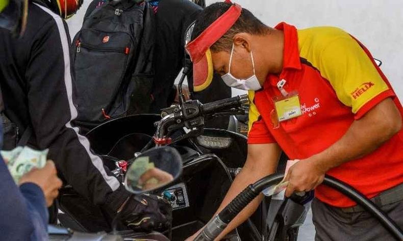 Funcionário de uma máscara enche tanque de uma moto em um posto em Bangcoc. Mercados acionários entraram em colapso por causa do coronavírus e a queda nos preços do petróleo(foto: Mladen ANTONOV / AFP) Funcionário de uma máscara enche tanque de uma moto em um posto em Bangcoc. Mercados acionários entraram em colapso por causa do coronavírus e a queda nos preços do petróleo(foto: Mladen ANTONOV / AFP)