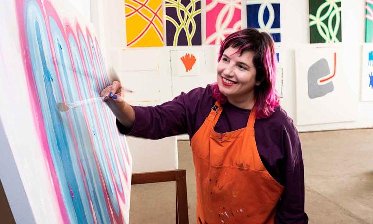 Artista plstica flvia coelho sorri e pinta quadro