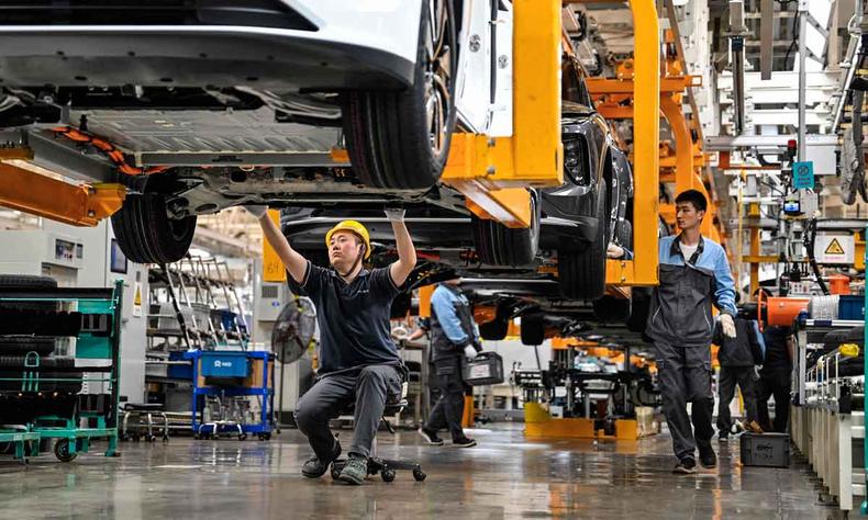 (foto: Hector RETAMAL / AFP) Produção de carros na China