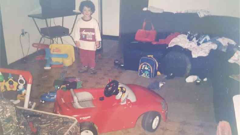 Dimy durante a infncia posa perto de carro de brinquedo