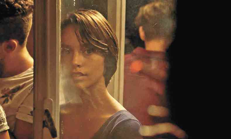 A atriz Tamara Rocca olha através de porta de vidro em cena de ''Como matar a besta'' 
