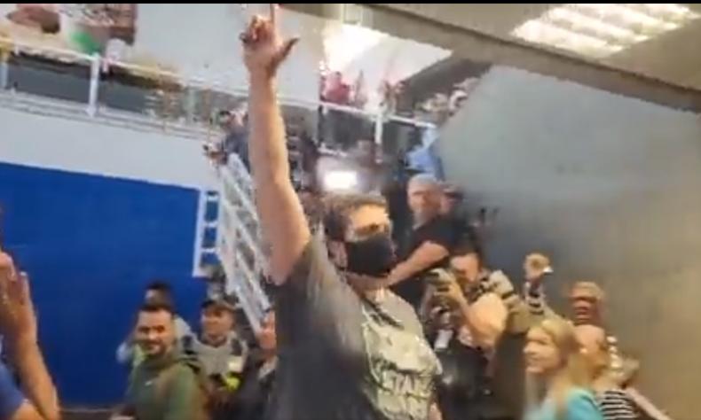 O homem disse que sabia que Bolsonaro estaria no avião, mesmo antes do embarque por já conhecer os horários dos voos(foto: Reprodução / Twitter) Homem fazendo o L em frente a bolsonaristas