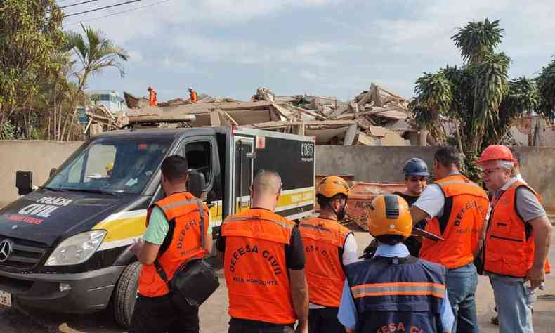 Agentes da defesa civil prximo ao edifcio que caiu