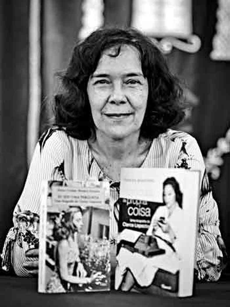 Teresa Montero sorri para a cmera, tendo ao seu lado as duas biografias que escreveu sobre Clarice Lispector