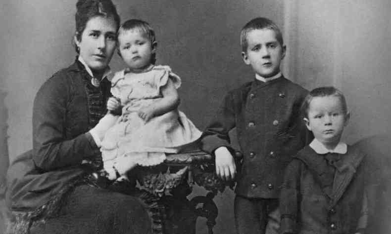 Jlia Mann est sentada com a filha Julia no colo. Ao lado dela, de p, esto os meninos Heinrich e Thomas Mann