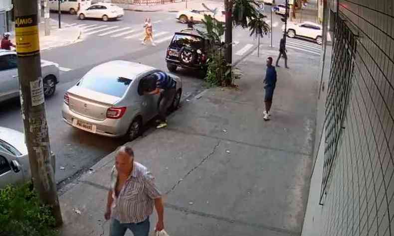 Momento em que um dos homens quebra o vidro e pega uma bolsa no banco traseiro do carro (foto: Reproduo/ Internet/ Facebook )