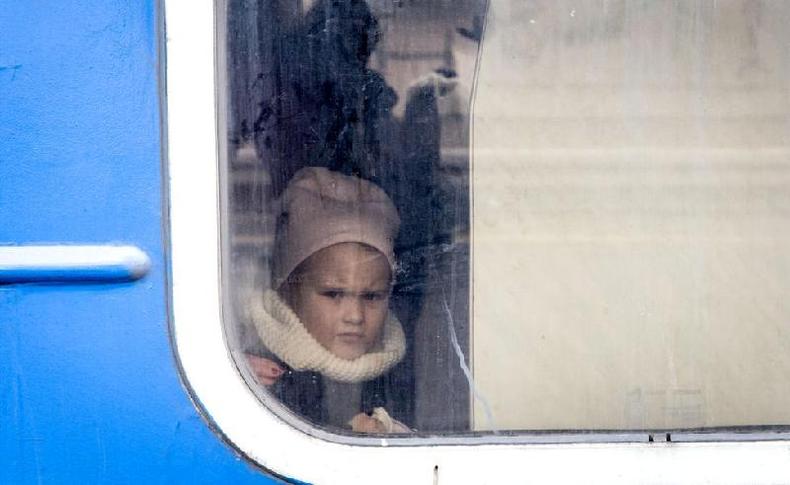 Uma jovem olha pela janela de um trem antes de sair carregando mulheres e crianas que fugiram dos combates em Bucha e Irpin da cidade de Irpin para Kiev, 4 de maro de 2022