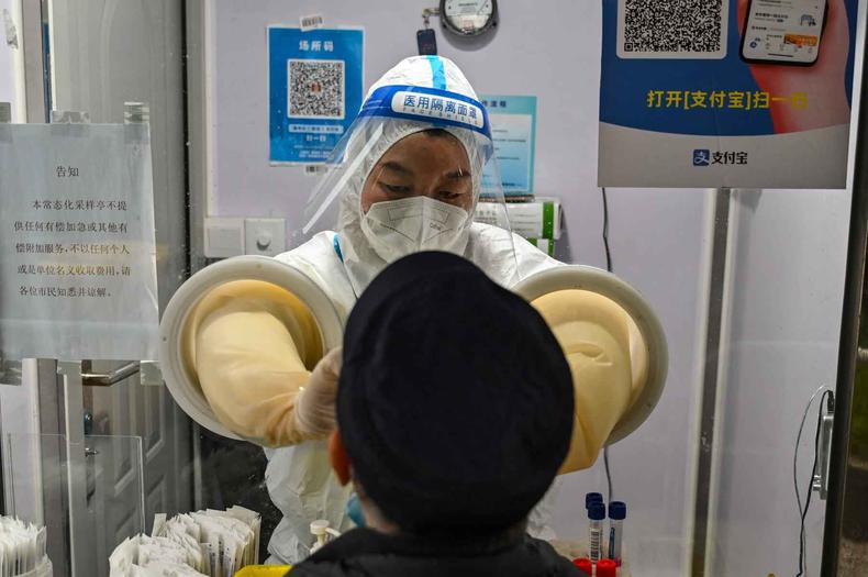 Na foto, profissional de sade faz teste em paciente na China
