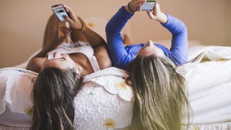 Ideias preconcebidas sobre uma pessoa que nos parece chata podem nos fazer perder a oportunidade de cultivar uma amizade inesperada(foto: Getty Images) Jovens olhando celulares