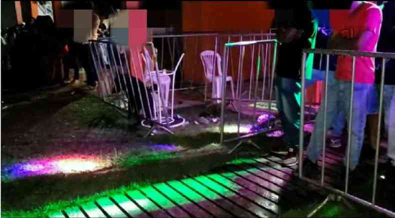 Pessoas detidas encostadas em grade sob as luzes da festa interrompida enquanto co fareja drogas(foto: PMMG)