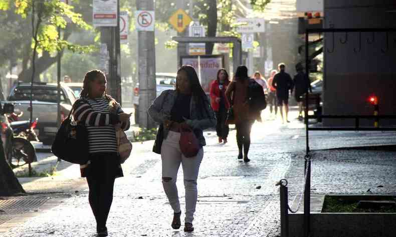 pessoas andando na calada com casacos 