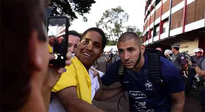 Torcedor tira foto ao lado do jogador francs Karim Benzema, em Ribeiro Preto (foto: AFP PHOTO / FRANCK FIFE )