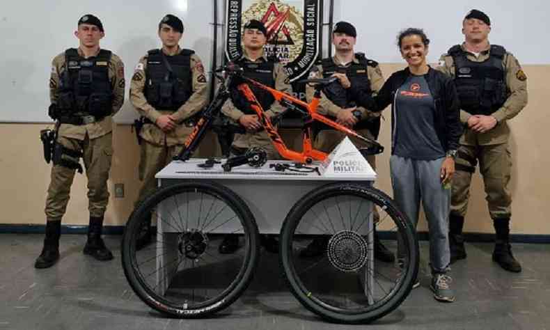 Herclia e policiais posam para foto ao lado da bicicleta recuperada 