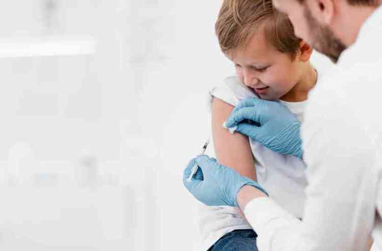 Mdico vacinando menino