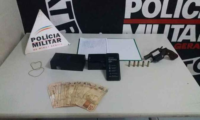 Dinheiro, arma, munições e um celular apreendido com o homem (foto: Polícia Militar/ Divulgação) Dinheiro, arma, munições e um celular apreendido com o homem (foto: Polícia Militar/ Divulgação)