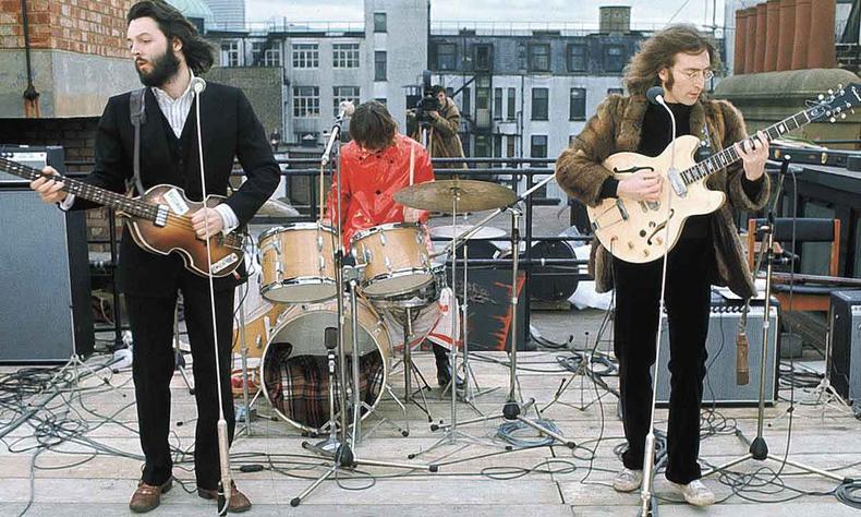 Em cena do documentrio Get back, Paul McCartney, Ringo Starr e John Lennon tocam no telhado de um prdio. Ao fundo, v-se um homem filmando com uma cmera