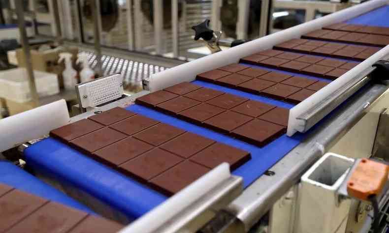 Esteira de uma fábrica de chocolates com algumas barras do produto