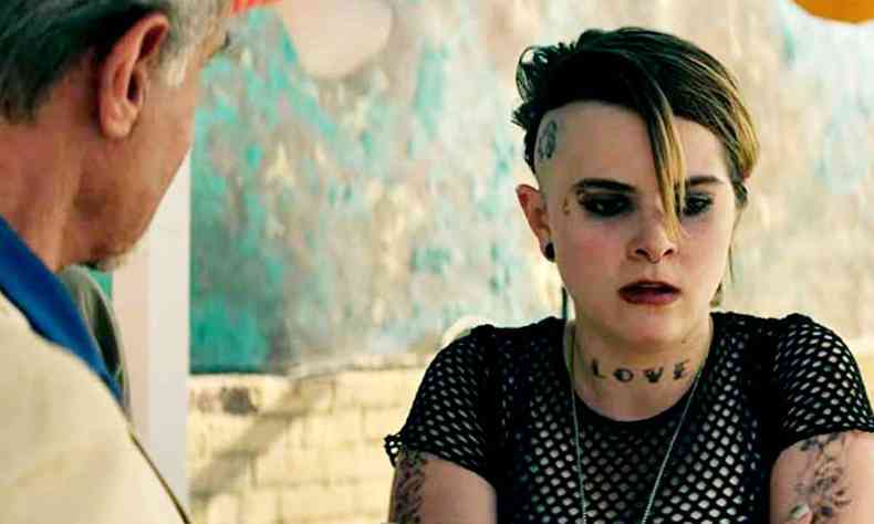 Jovem garota com cabelo de corte punk e tatuagens olha para baixo em cena da srie Tulsa King