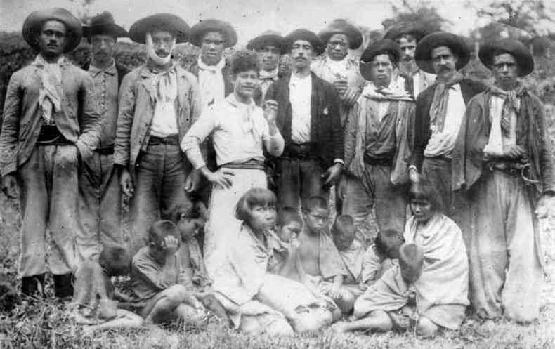 Em p, bugreiros posam com mulheres e crianas do povo Xokleng capturadas aps ataque a acampamento.