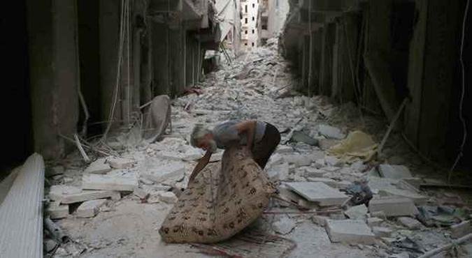 Homem carrega colchão em meio aos destroços da cidade de Allepo, que sofre constantes bombardeios do governo de Bashar Al Assad(foto: AFP PHOTO / AMC/ BARAA AL-HALABI) Homem carrega colchão em meio aos destroços da cidade de Allepo, que sofre constantes bombardeios do governo de Bashar Al Assad(foto: AFP PHOTO / AMC/ BARAA AL-HALABI)
