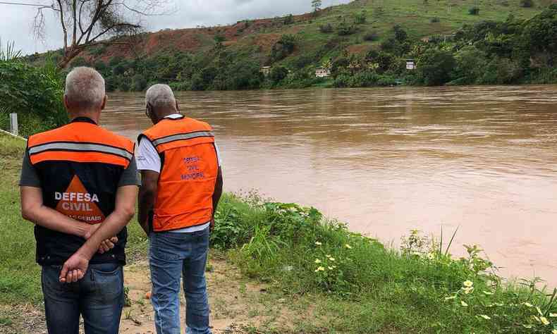 Dois agente da Defesa Civil prximas a um rio