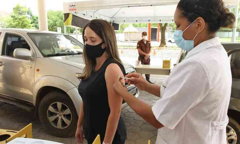Enfermeira aplicando vacina da Pfizer no braço 