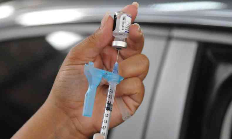 Profissional de sade prepara vacina para aplicar em frequentador de posto drive-thru da Prefeitura de BH