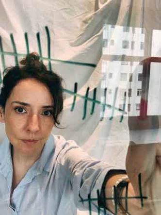 Sabrina Abreu fez poesia durante o isolamento social em seu apartamento, na capital paulista(foto: Gulliver/divulgação) A escritora e jornalista Sabrina Abreu faz selfie em seu apartamento, tendo ao fundo o reflexo de um prédio na janela