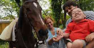 Com mucopolissacaridose, Victor Hugo alimenta cavalo no Cepel, com a ajuda dos especialistas Lilian e Thiago(foto: Cristina Horta/EM/DA Press)