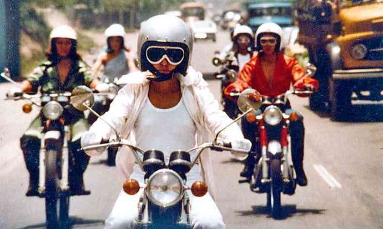 de capacete e culos, atrizes pilotam motocicletas na estrada em cena de feminino plural 