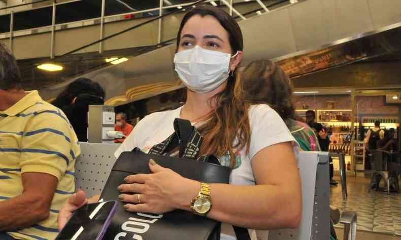 Deise Silveira, cirurgiã dentista de 39 anos segura uma mochila sentada no hall de espera da rodoviária de BH