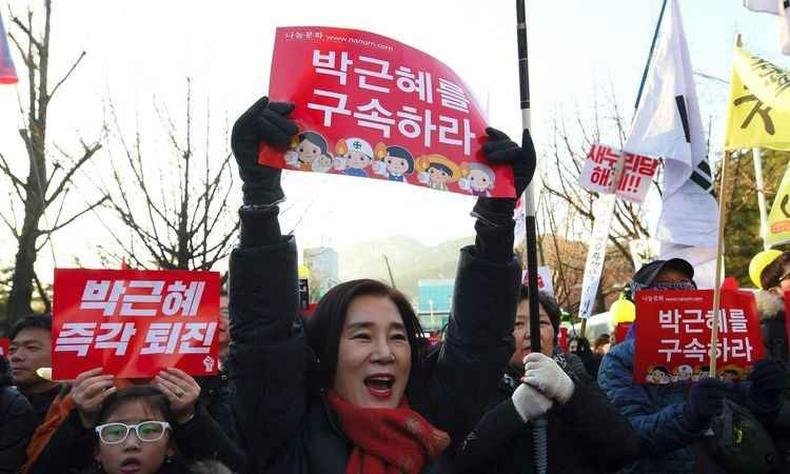 Segurando placas, bandeiras e bal�es amarelos, manifestantes gritavam alegremente para que Park Geun-hye sa�sse imediatamente, em vez de enfrentar o processo judicia(foto: AFP/JUNG Yeon-Je )
