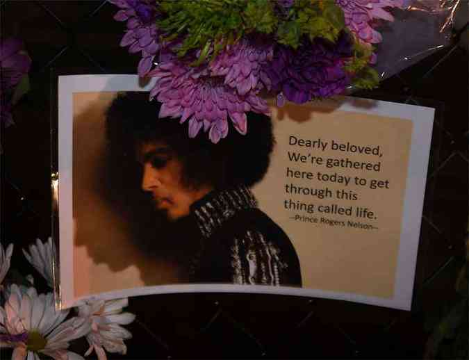 Fs deixam flores e velas do lado de fora de Paisley Park, onde Prince morava, em Minneapolis, Minnesota.(foto: AFP / Mark Ralston )