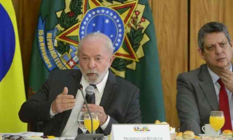 Lula discursa sentado em uma mesa