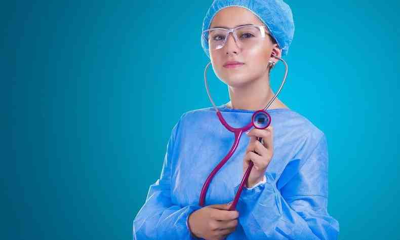 Médica paramentada para entrar em cirurgia, com uniforme azul e estetoscópio
