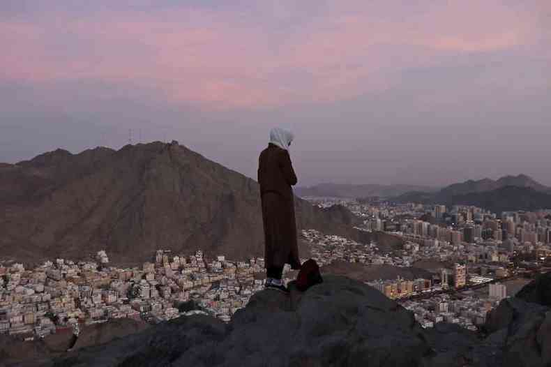Peregrina observa a cidade de Meca do alto de uma montanha