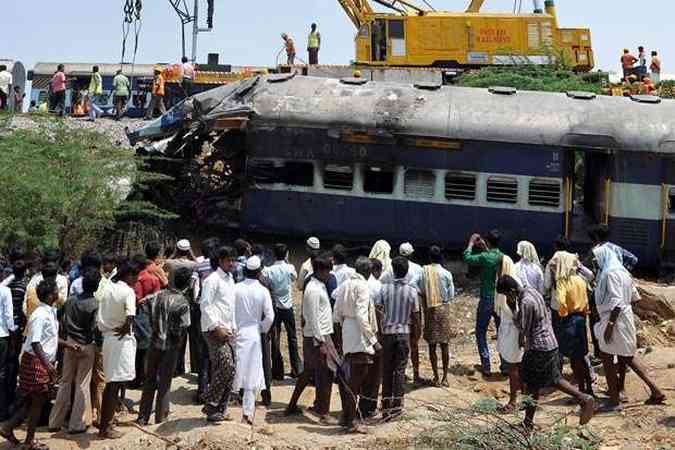 Moradores acompanham resgate de feridos da coliso entre um trem de passageiros e um trem de cargas(foto: Manjunath Kiran / AFP)