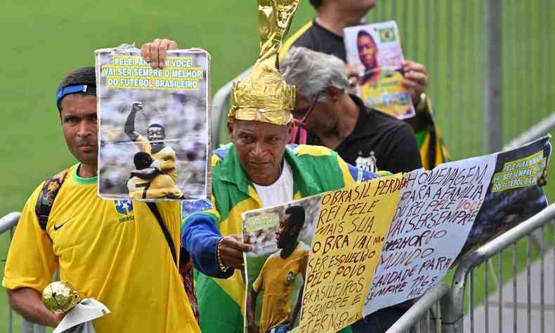 Fs com camisa da Seleo Brasileira, cartazes e rplica de trofus fazem fila durante o velrio de Pel, em Santos