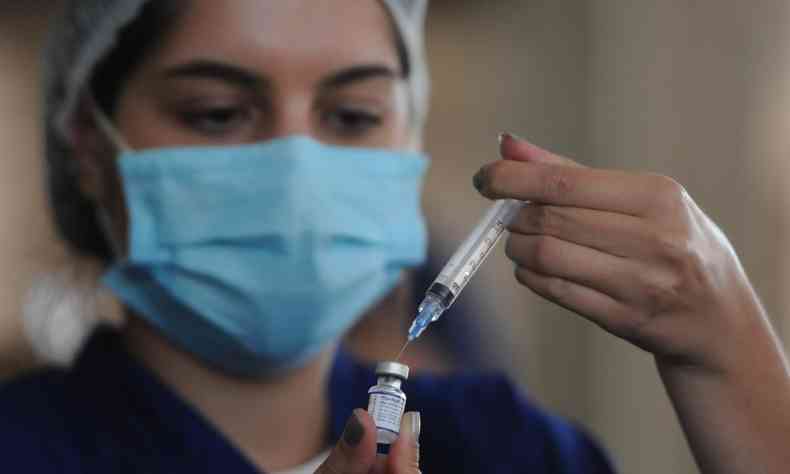 mulher prepara aplicao de vacina contra COVID-19