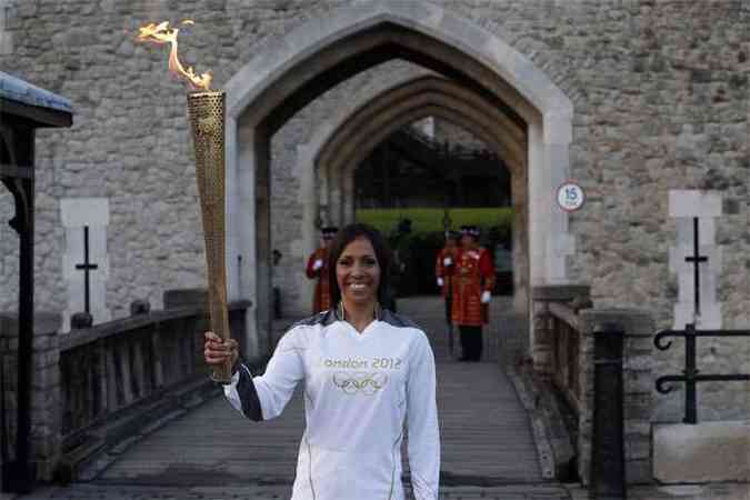 A britnica Kelly Holmes conduz a tocha olmpica pela Torre de Londres(foto: REUTERS/Suzanne Plunkett )