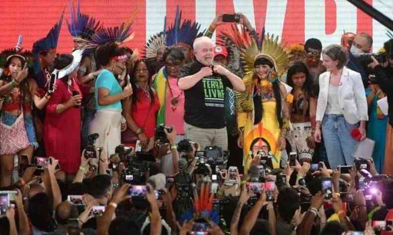 O presidente Luiz Inácio Lula da Silva (PT) posa com lideranças indígenas usando uma camisa do Acampamento Terra Livre em abril de 2022 em visita ao local.