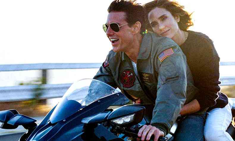 Atores Tom Cruise e Jennifer Connely estão numa moto, em cena de Top Gun: Maverick