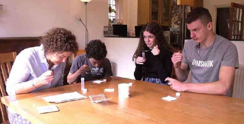 Jayne e seus trs filhos adolescentes, Sam, Meg e Billy, cuspindo em uma colher para realizar teste de coronavrus(foto: BBC)