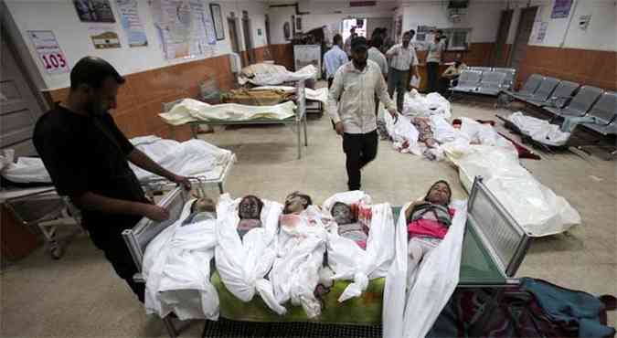 Palestino olha para grupo de meninos mortos em hospital na faixa de Gaza, ofensiva israelense j matou mais 230 crianas (foto: REUTERS/Ibraheem Abu Mustafa)