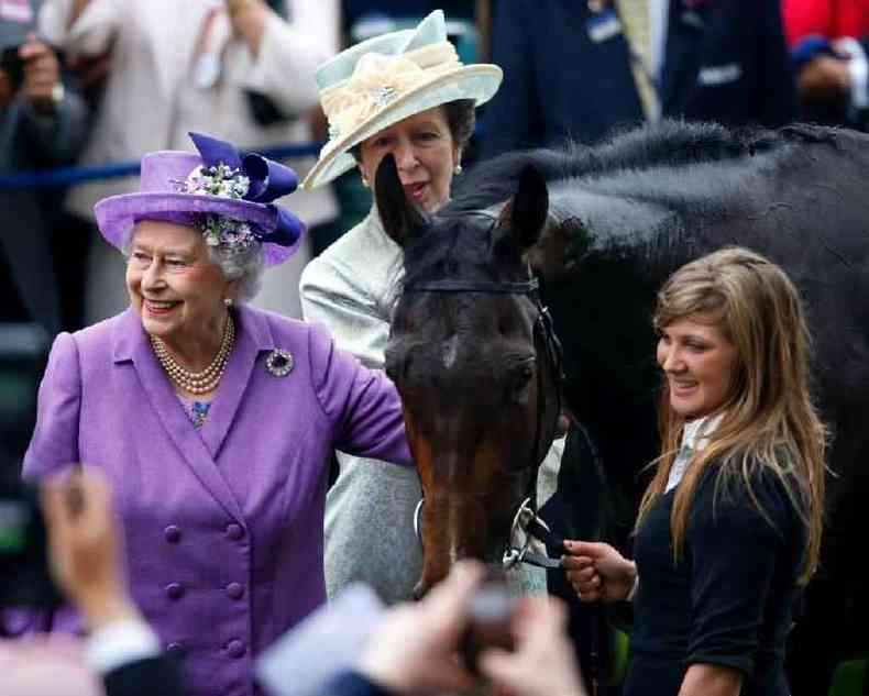 A rainha Elizabeth 2 sorrindo ao lado de cavalo e de outras pessoas