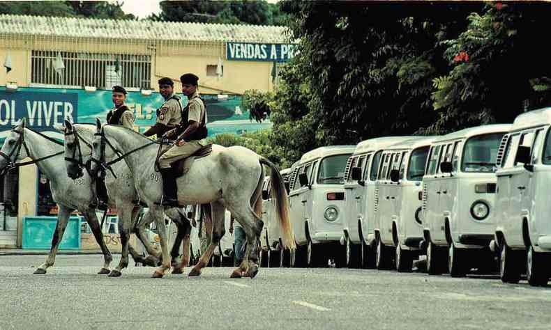 Policiais a cavalo policiam a rua com várias kombis estacionadas durante a greve dos perueiros, em BH, em 2001