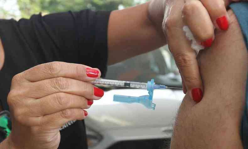 Profissional de sade aplica vacina contra a COVID em morador de BH