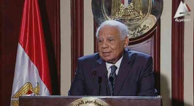 O primeiro-ministro Hazem el-Beblawi anuncia sua renncia em TV egpcia. (foto: TV egpcia/AFP)